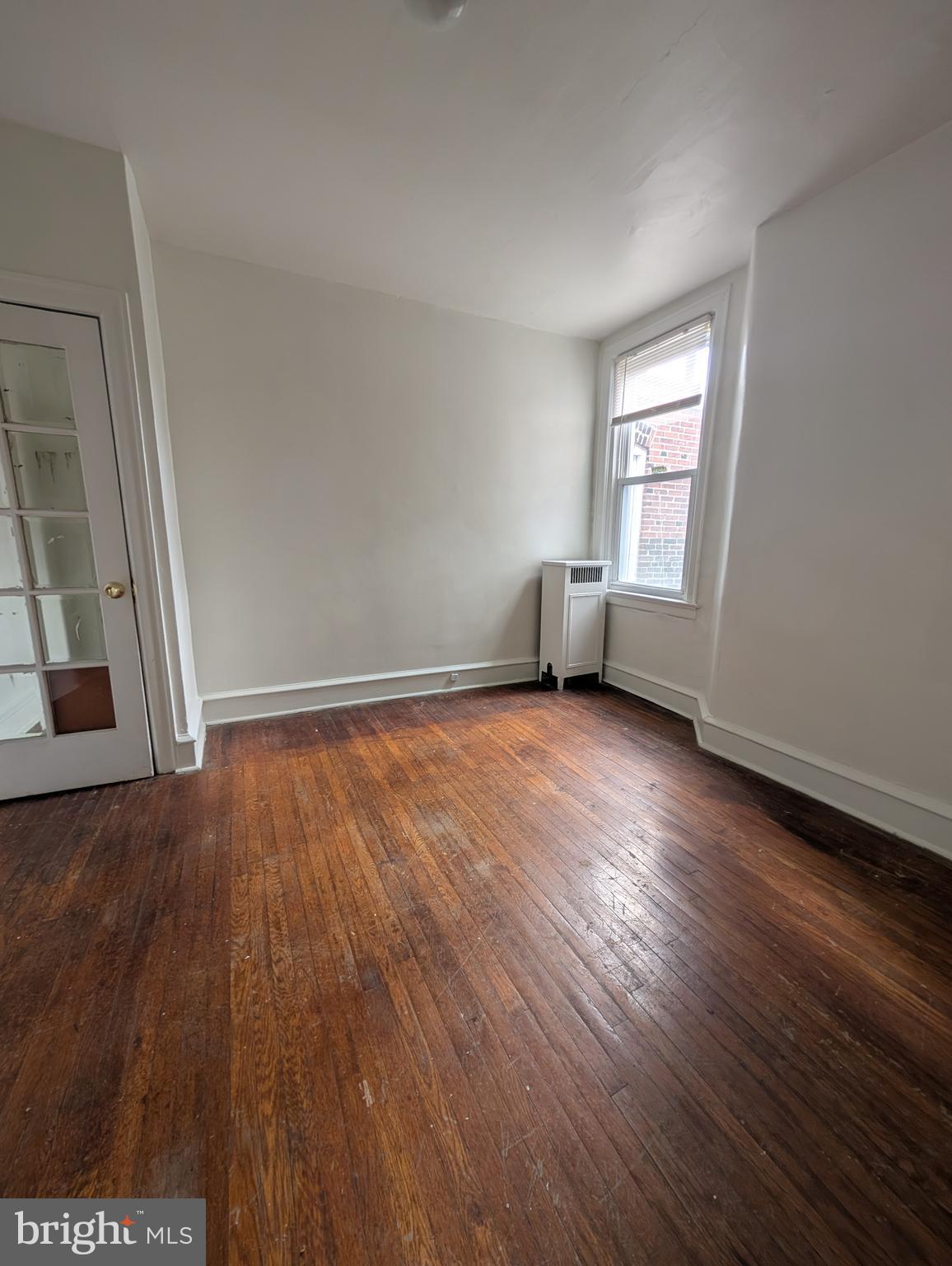 5927 Springfield Avenue Philadelphia, PA 19143 - Photo 8 of 17 an empty room with wooden floor and windows