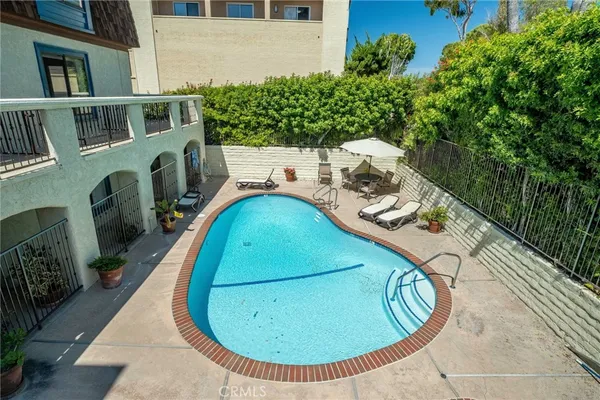 an aerial view of a house with swimming pool and large trees