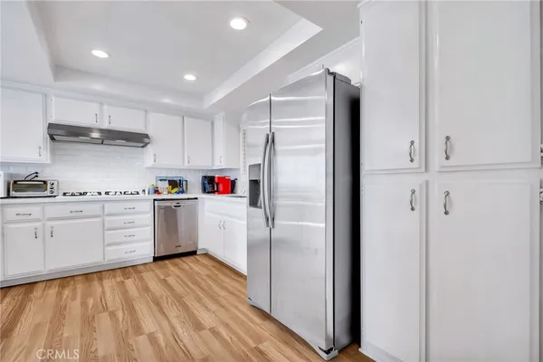 a kitchen with white cabinets and white appliances