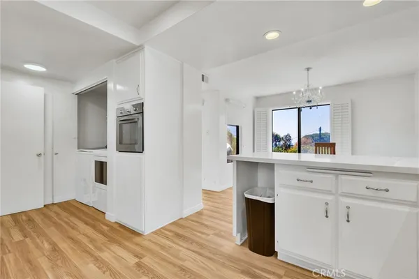 a kitchen with cabinets and wooden floor