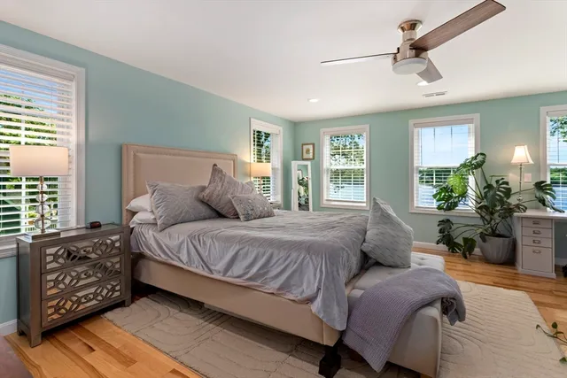 a bedroom with a large bed and windows