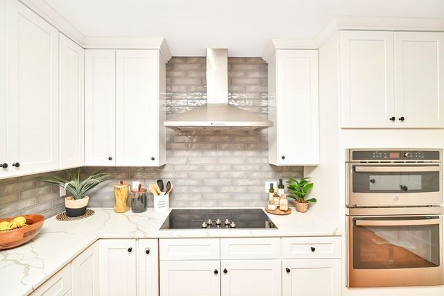 a kitchen with granite countertop white cabinets and white appliances