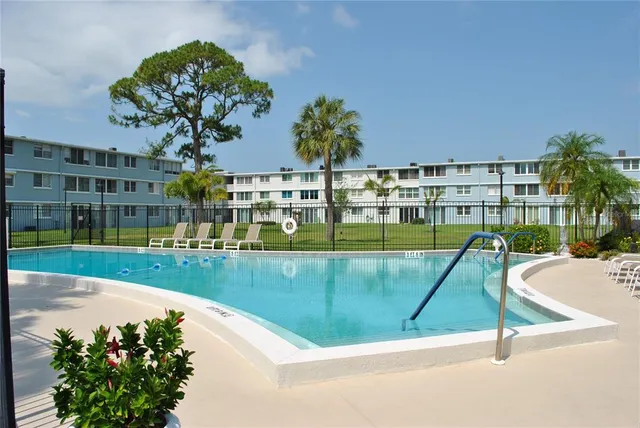 a view of a swimming pool with a fountain and a bench in the patio