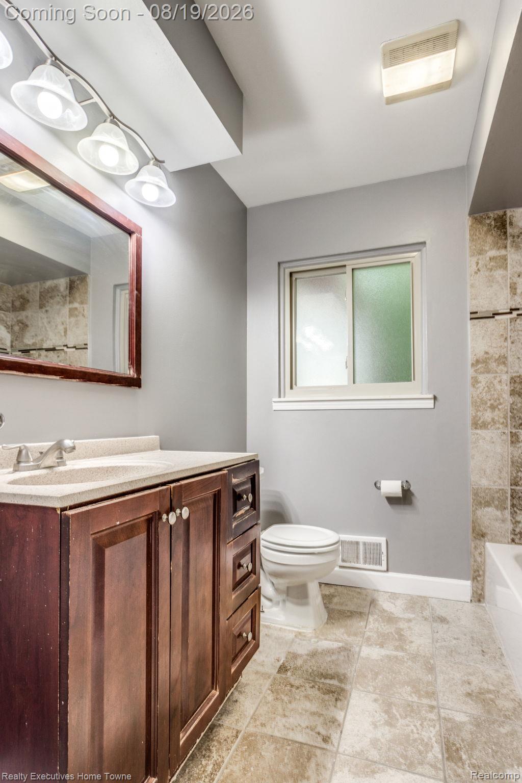 2448 Oakcrest Road Sterling Heights, MI 48310 - Photo 13 of 31 Bathroom with wood-finish vanity, light-toned countertop, and a built-in rectangular sink