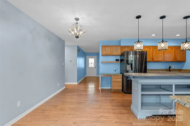 a view of a kitchen with a sink and dishwasher cabinet with wooden floor