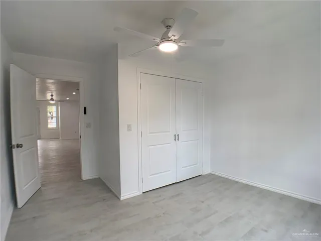 an empty room with a white walls and ceiling fan