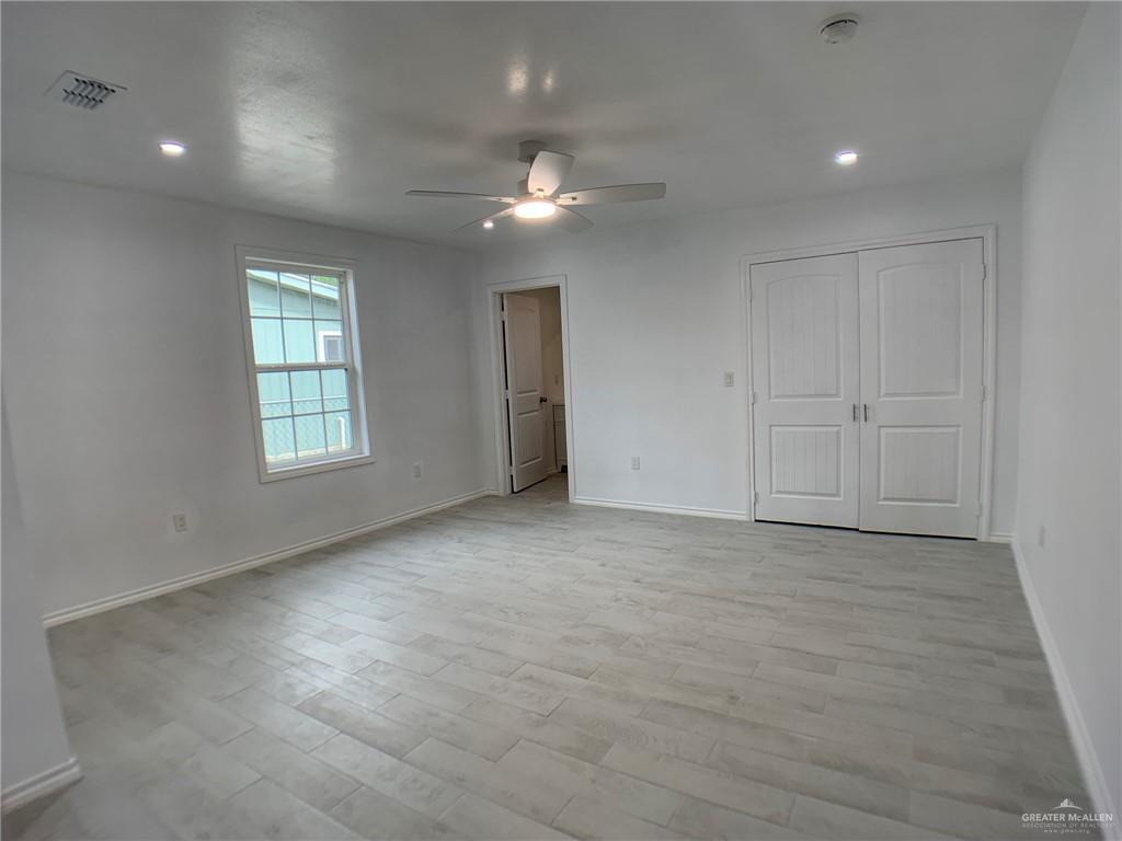 10824 Compadres Street Mercedes, TX 78570 - Photo 14 of 19 an empty room with chandelier fan and windows