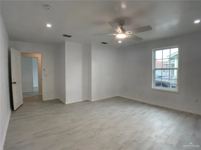 an empty room with closet and windows