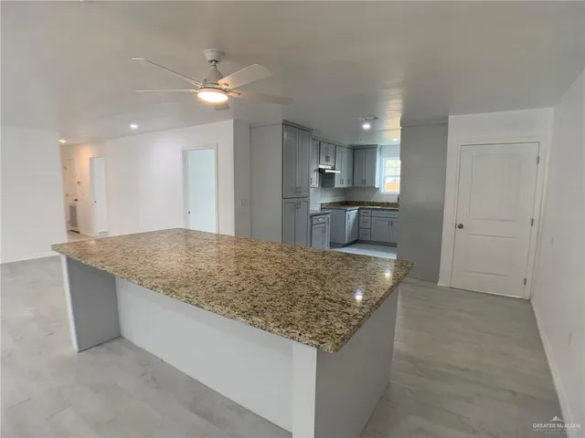 a kitchen with granite countertop counter top space sink and center island