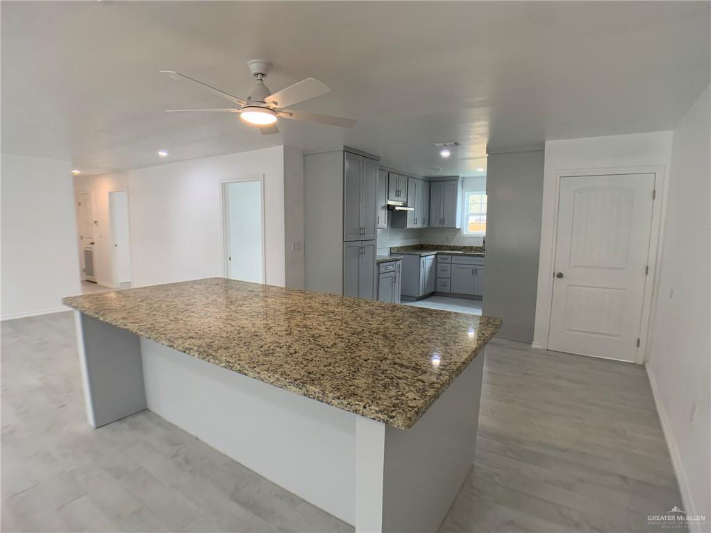 10824 Compadres Street Mercedes, TX 78570 - Photo 5 of 19 a kitchen with granite countertop counter top space sink and center island