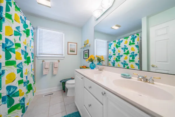 a kitchen with stainless steel appliances granite countertop a dining table chairs stove and white cabinets