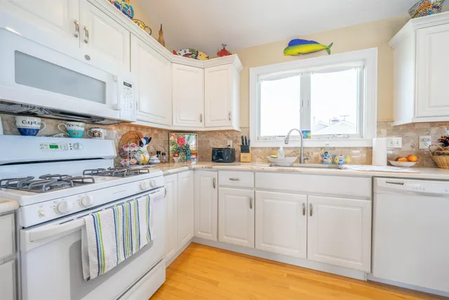 a kitchen with stainless steel appliances granite countertop a sink a stove and a window