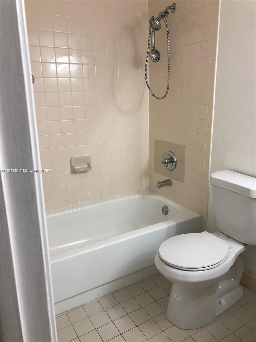 a white toilet sitting next to a bath tub shower