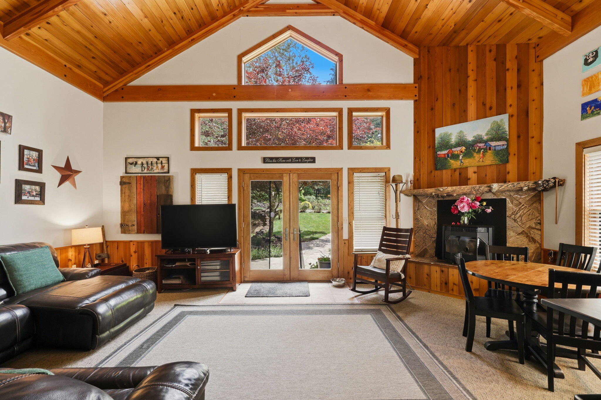 985 Elliott Creek Road Wilderville, OR 97543 - Photo 64 of 98 a living room with furniture a flat screen tv and a floor to ceiling window