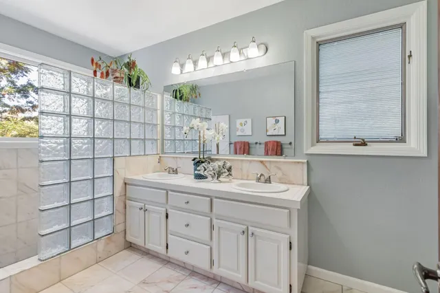 a bathroom with a double vanity sink a mirror and a bathtub