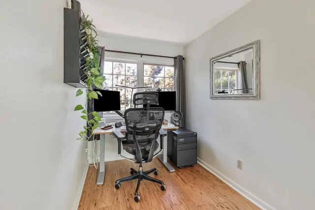 a view of a workspace with furniture and a window