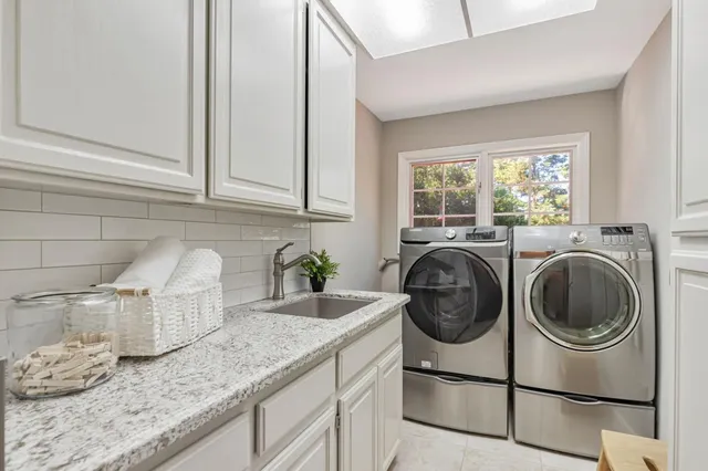 a utility room with sink dryer and washer