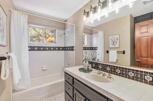 a bathroom with a tub a sink and mirror