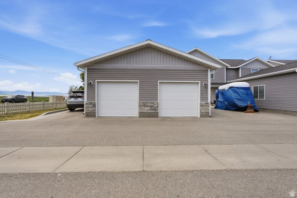 391 South 440th Street West Preston, ID 83263 - Photo 22 of 28 Two-car garage featuring white paneled doors and stone veneer accents