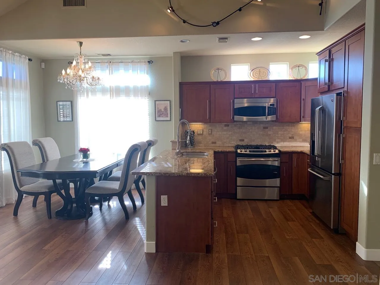 12602 Springbrook Drive, Unit B San Diego, CA 92128 - Photo 13 of 27 a kitchen with stainless steel appliances wooden floors and wooden cabinets