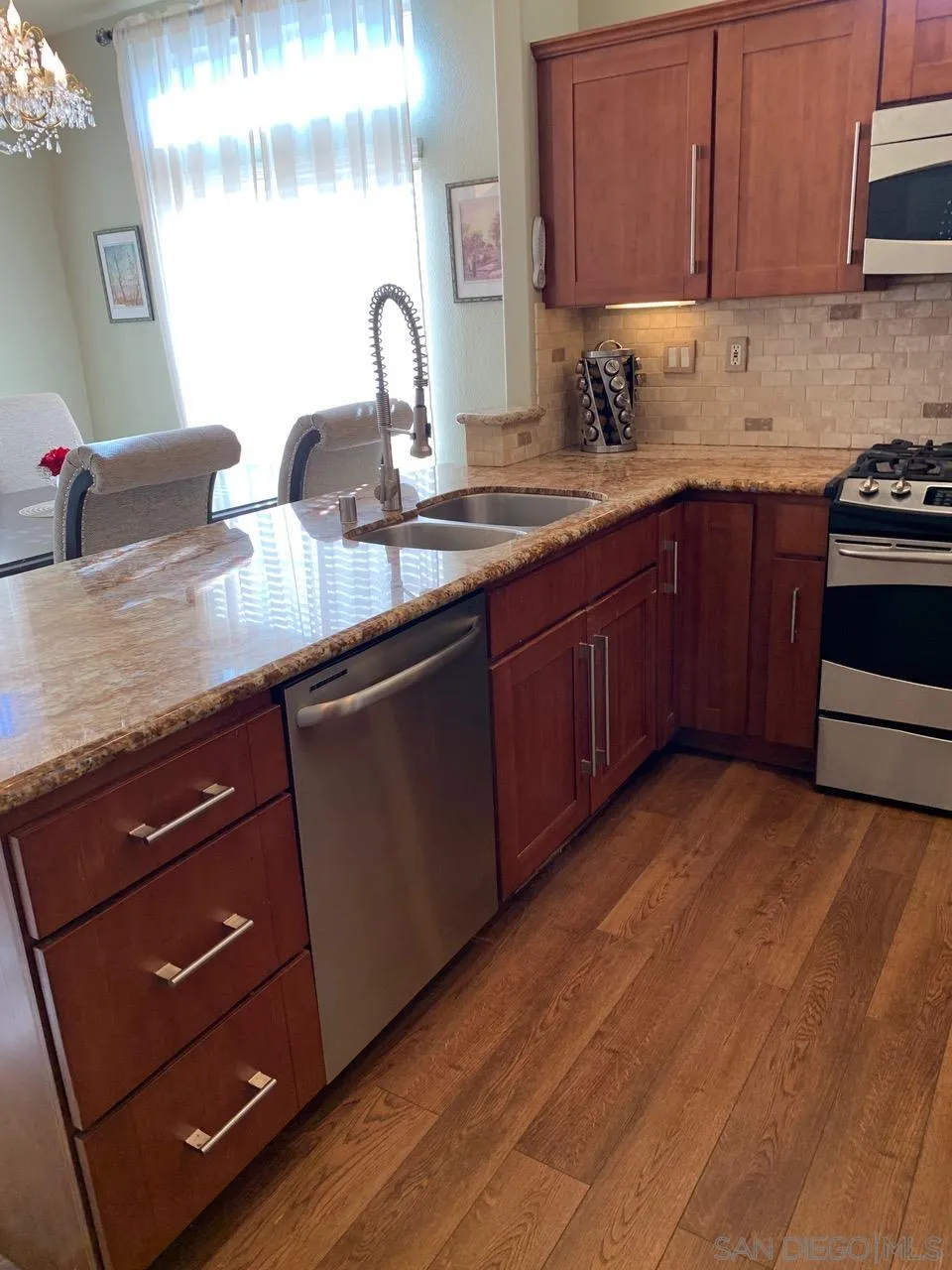 12602 Springbrook Drive, Unit B San Diego, CA 92128 - Photo 4 of 27 a kitchen with stainless steel appliances granite countertop a sink a stove and cabinets