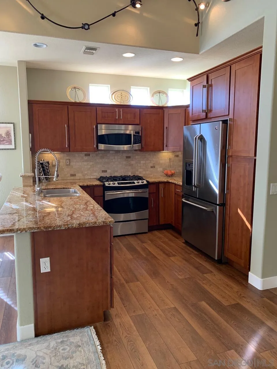 12602 Springbrook Drive, Unit B San Diego, CA 92128 - Photo 5 of 27 a kitchen with stainless steel appliances granite countertop a stove a refrigerator and a sink
