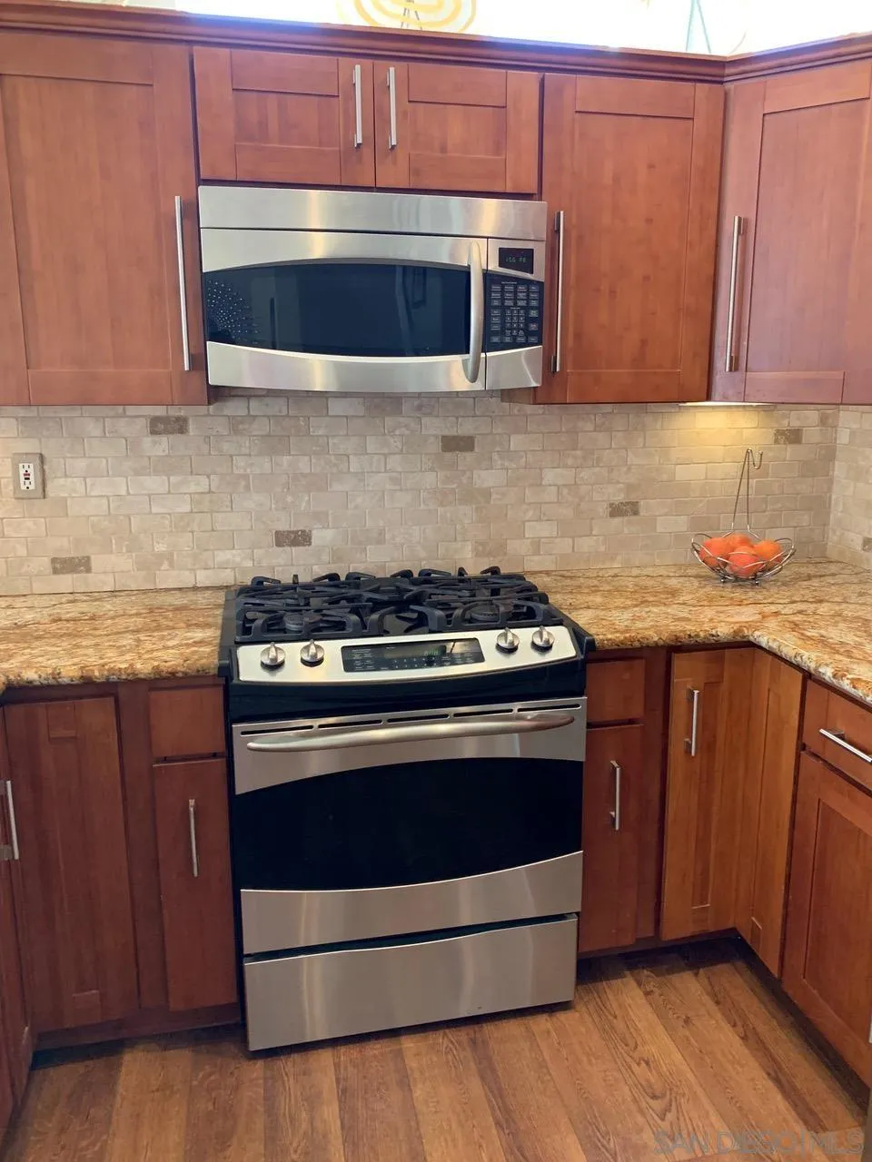 12602 Springbrook Drive, Unit B San Diego, CA 92128 - Photo 6 of 27 a kitchen with granite countertop wood cabinets and stainless steel appliances