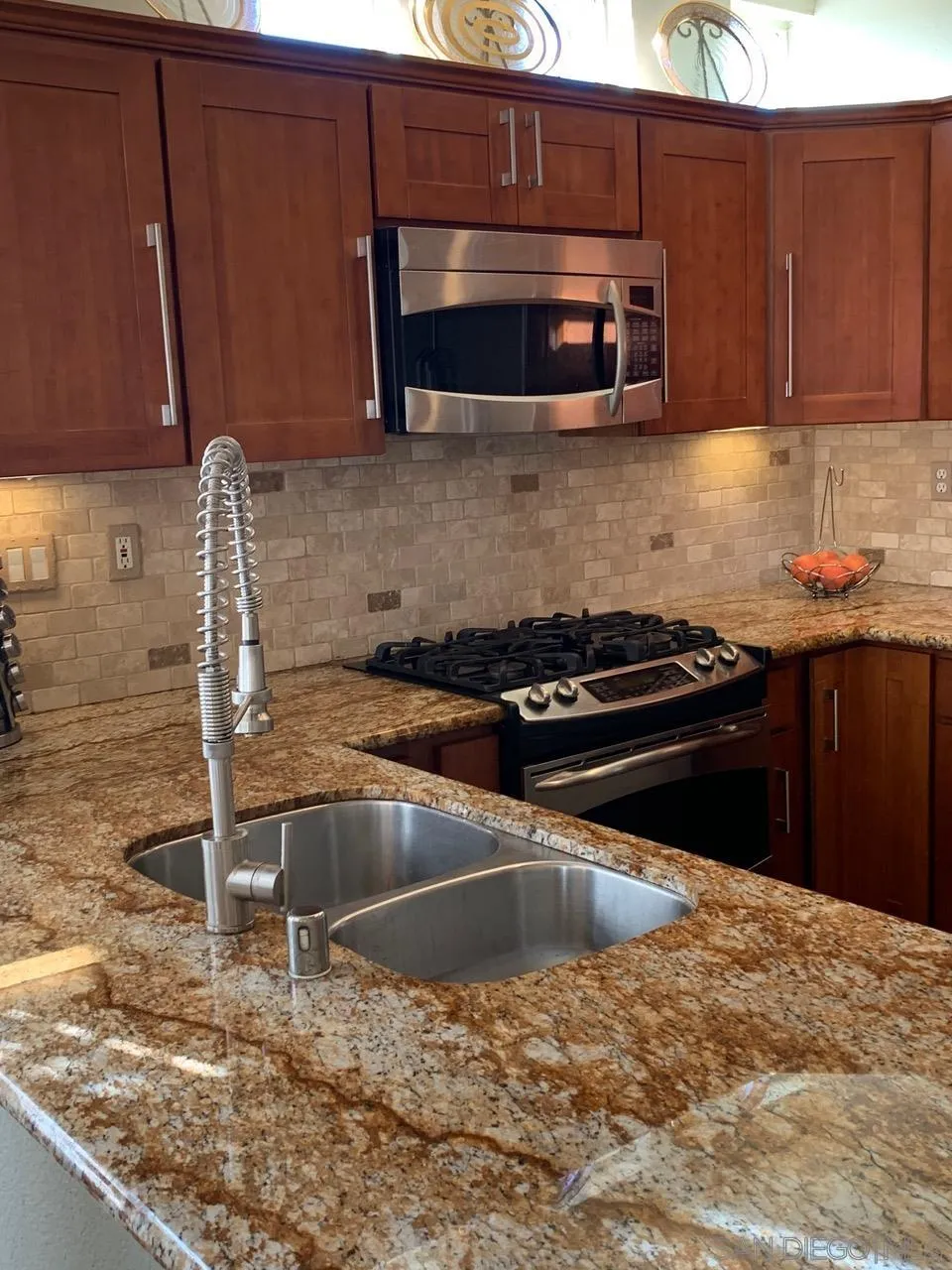 12602 Springbrook Drive, Unit B San Diego, CA 92128 - Photo 10 of 27 a kitchen with granite countertop a stove and a microwave