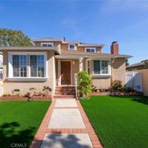 a front view of a house with a yard and potted plants