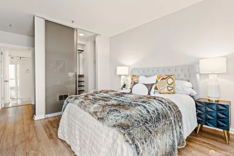 a bedroom with a bed and wooden floor