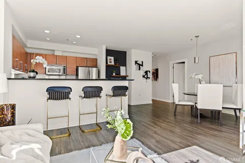a living room with furniture a wooden floor and next to a window