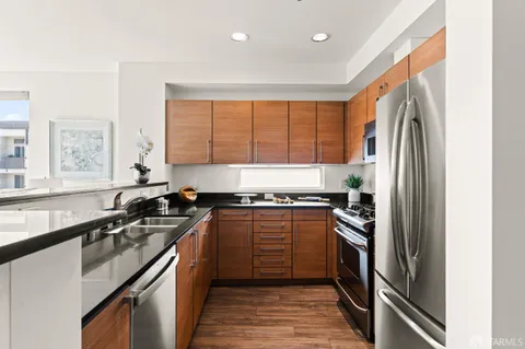 a kitchen with stainless steel appliances granite countertop a sink stove and refrigerator