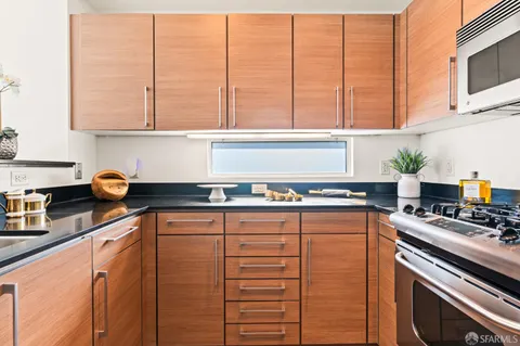 a kitchen with stainless steel appliances granite countertop a stove and a white cabinets