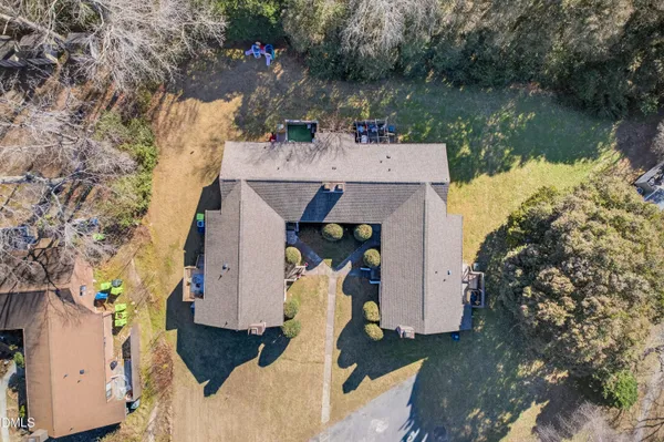 an aerial view of a house with a yard and a large tree
