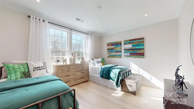 a bedroom with two beds and a large window