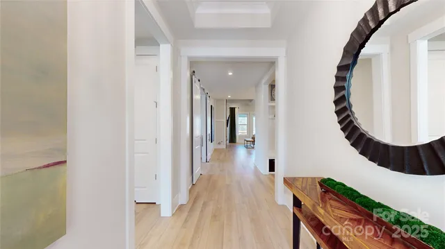 a view of a hallway with wooden floor and staircase