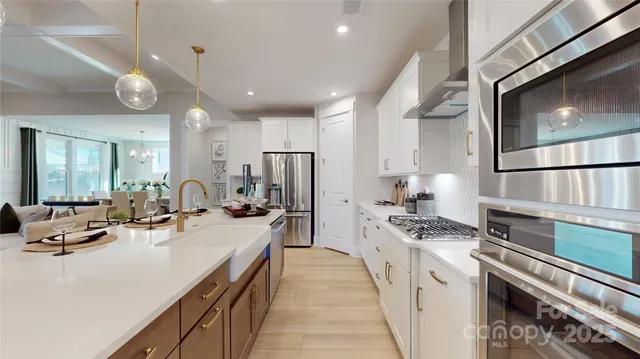 a kitchen with stainless steel appliances a sink a stove top oven a counter space and cabinets