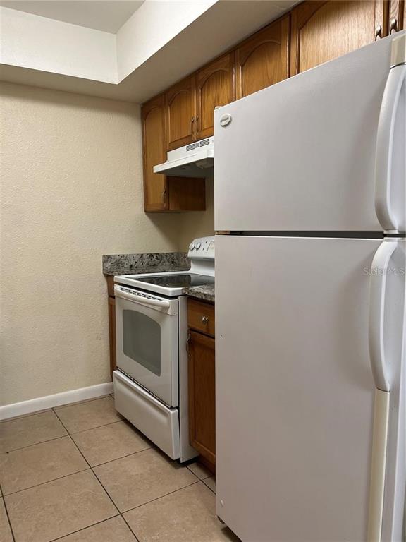 2176 Winchester Road North, Unit 2 St. Petersburg, FL 33710 - Photo 4 of 9 a white refrigerator freezer and a stove sitting inside of a kitchen