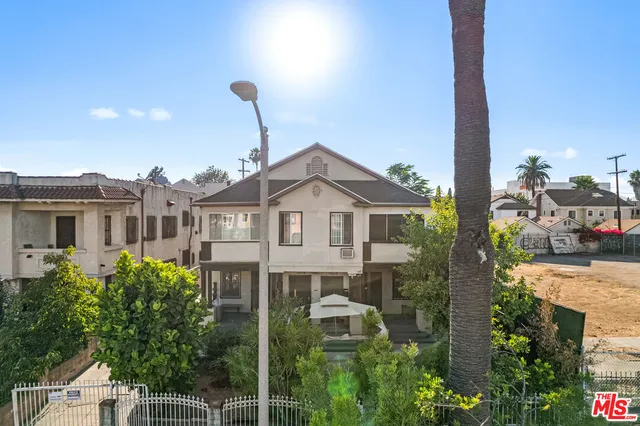 a front view of a house with a yard and fountain