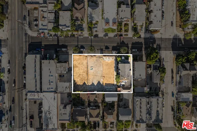 a view of a building with a couple of people and trees