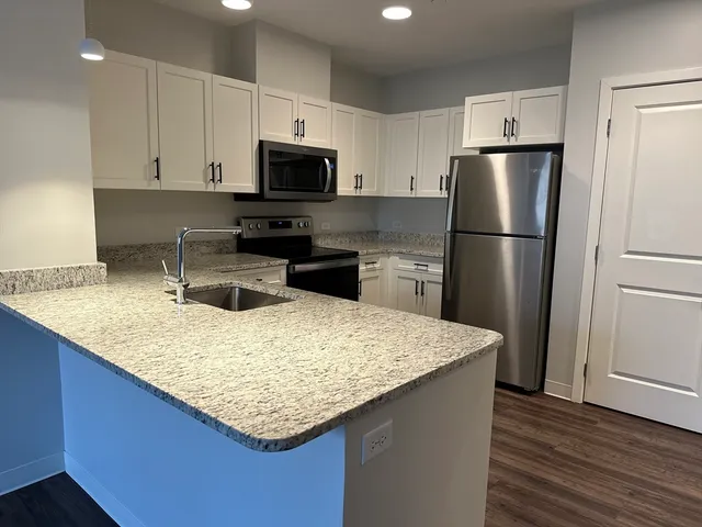 a kitchen with stainless steel appliances granite countertop a refrigerator sink microwave and stove