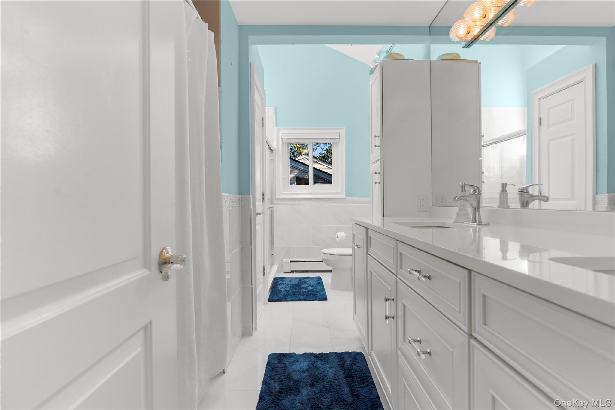 28 Annandale Road Commack, NY 11725 - Photo 21 of 29 a bathroom with a double vanity sink a two mirror a window and a bathtub