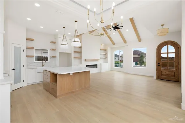 a view of a hallway with a chandelier fan and windows