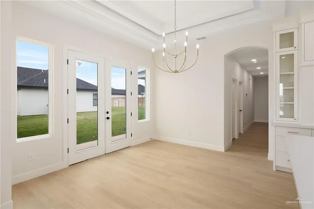 a large white kitchen with a sink a refrigerator and window
