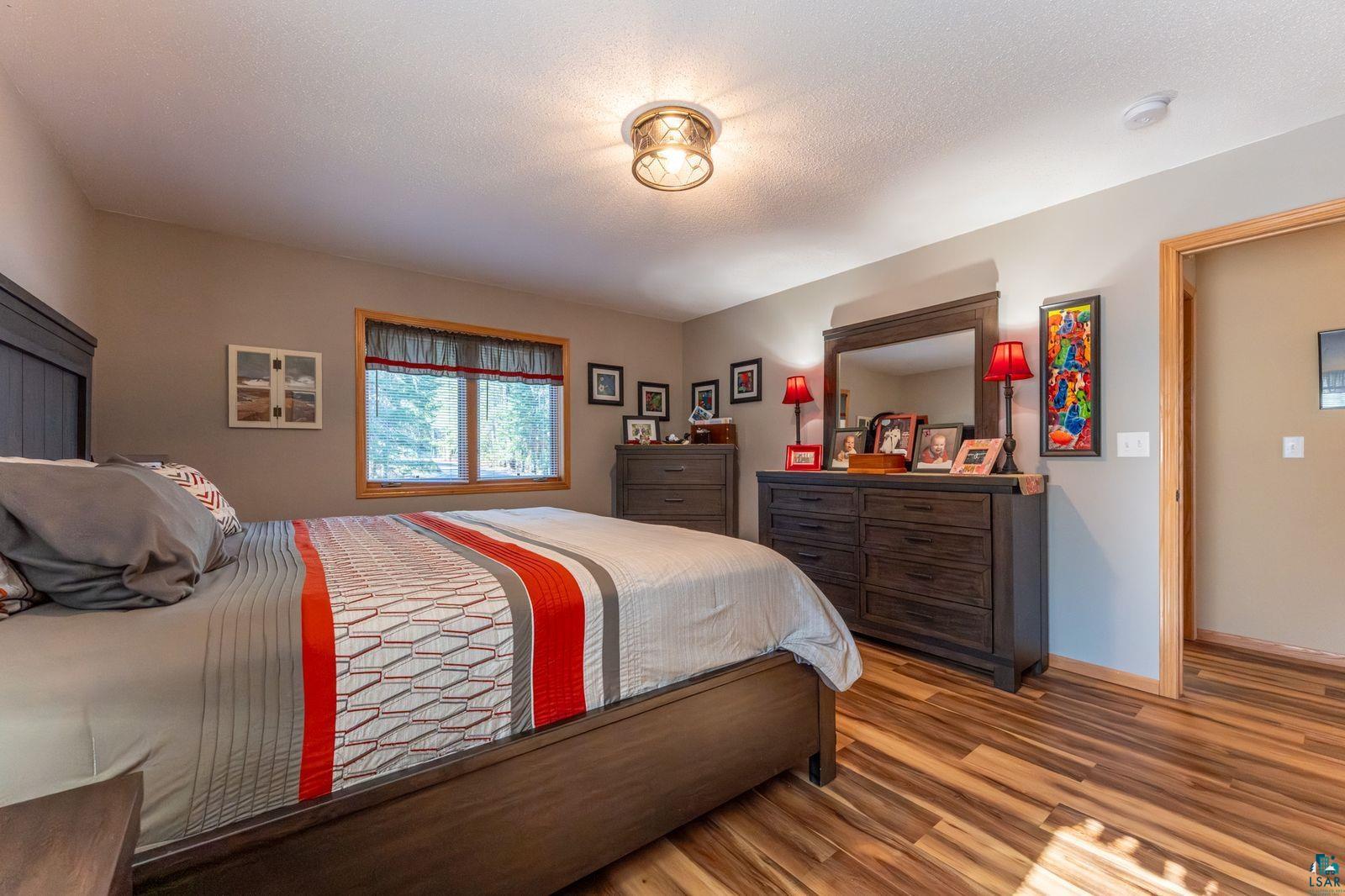 4452 Moccasin Point Road Tower, MN 55790 - Photo 13 of 44 Room featuring wood-finish flooring, a window with wood trim, and a ceiling-mounted light fixture