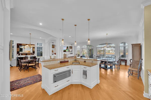 a living room with furniture and a dining table with wooden floor