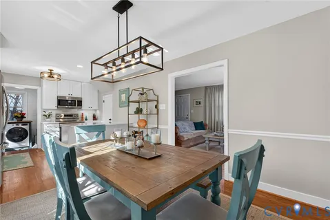 a view of a dining room with furniture a chandelier and wooden floor
