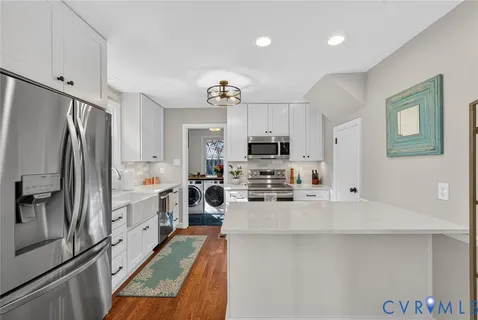a kitchen with stainless steel appliances a refrigerator sink and microwave