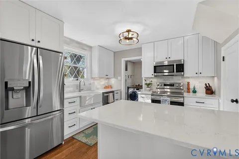 a kitchen with white cabinets and stainless steel appliances