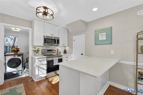 a kitchen with a refrigerator and a stove top oven